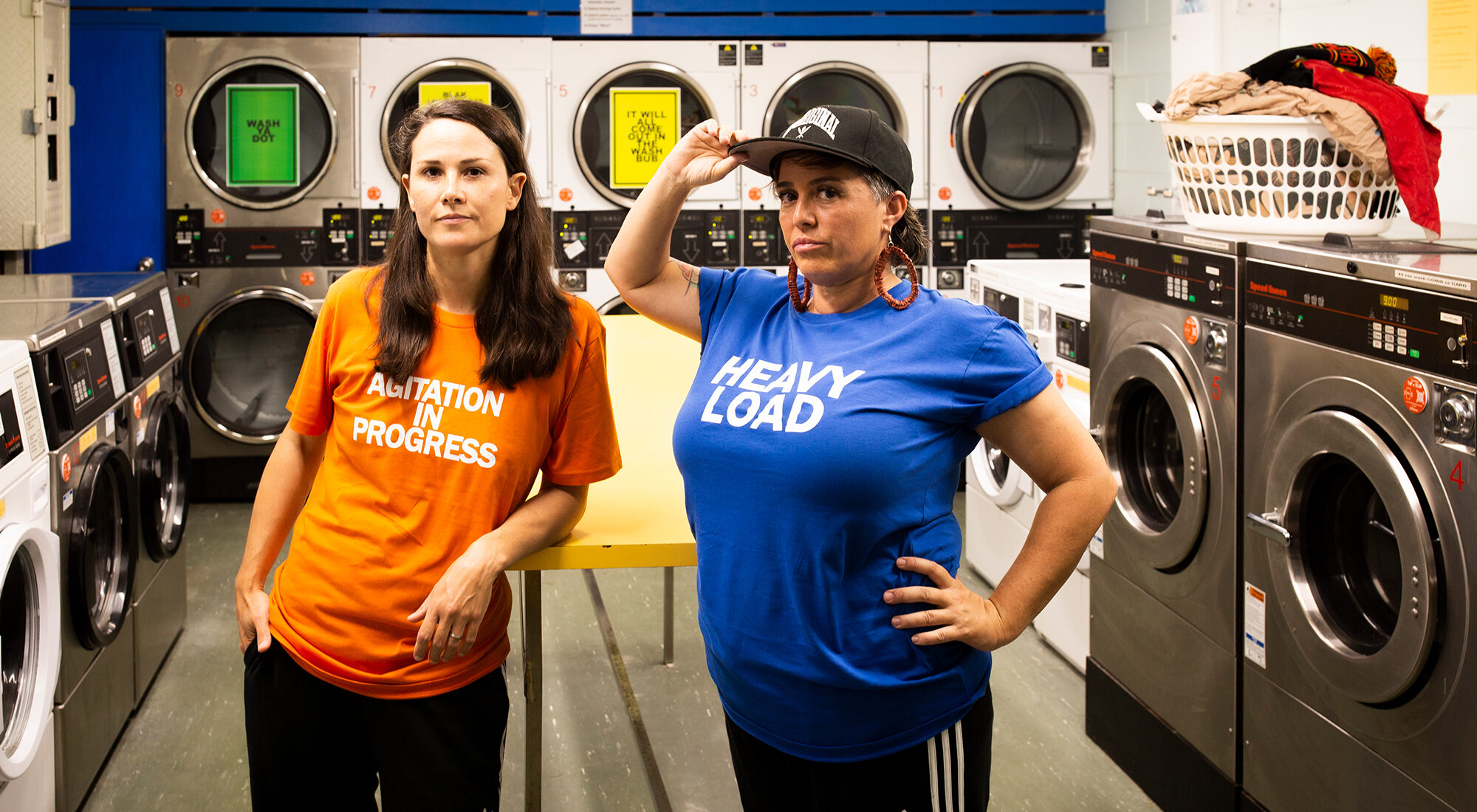 Two first nation artists stood in a coin laundry.