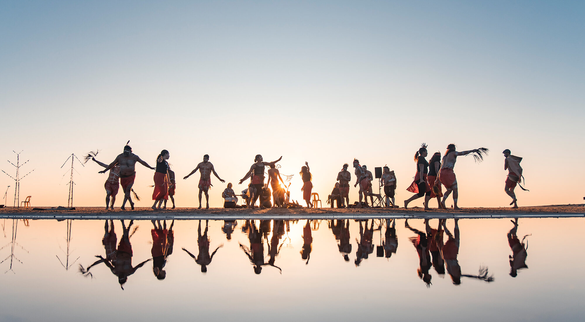 First Nation dancers dancing on the horizon line.