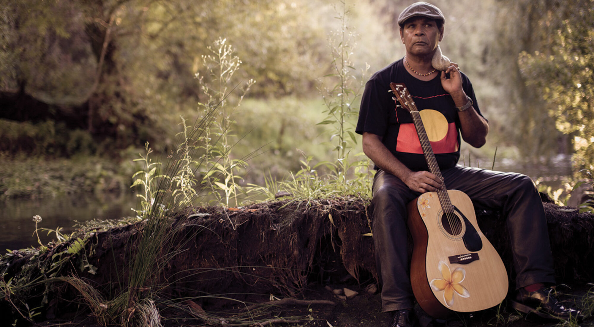 A First Nations person stood with their guitar.